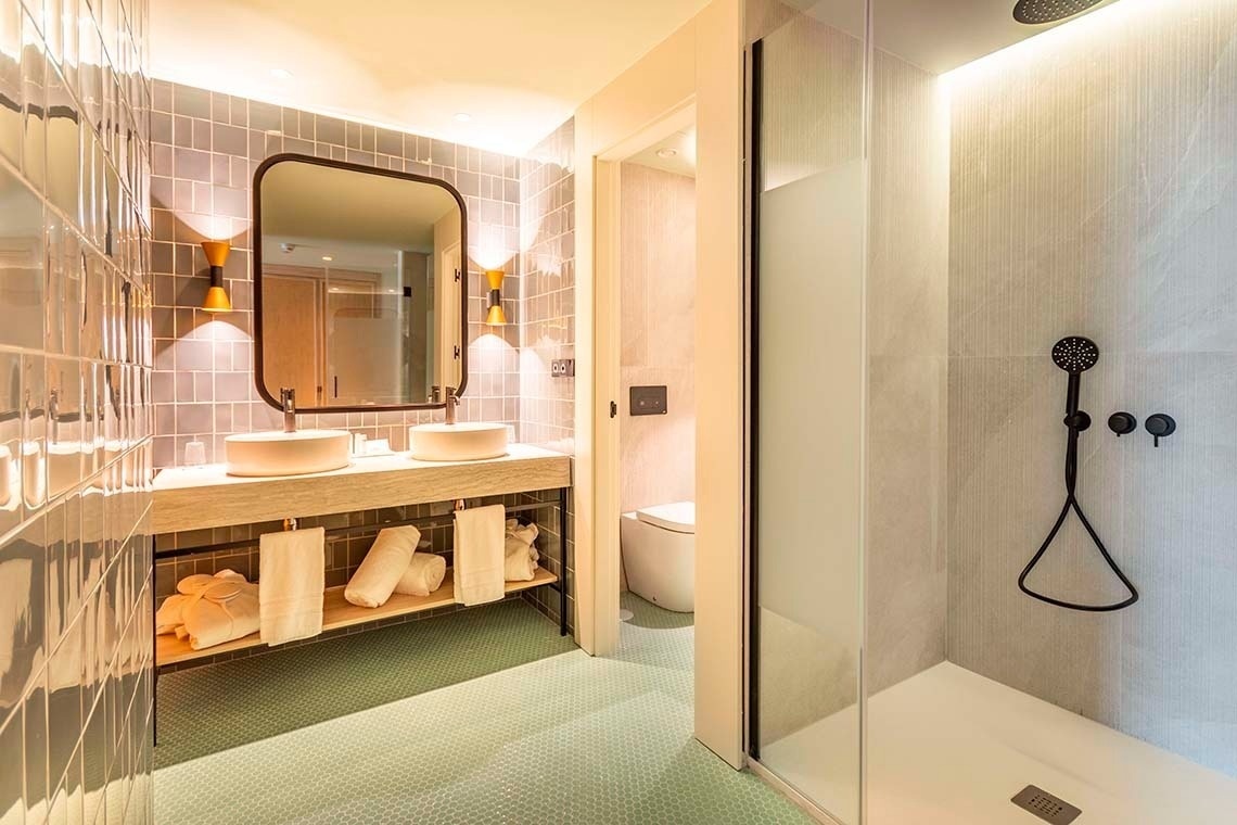 a bathroom with two sinks and a walk in shower