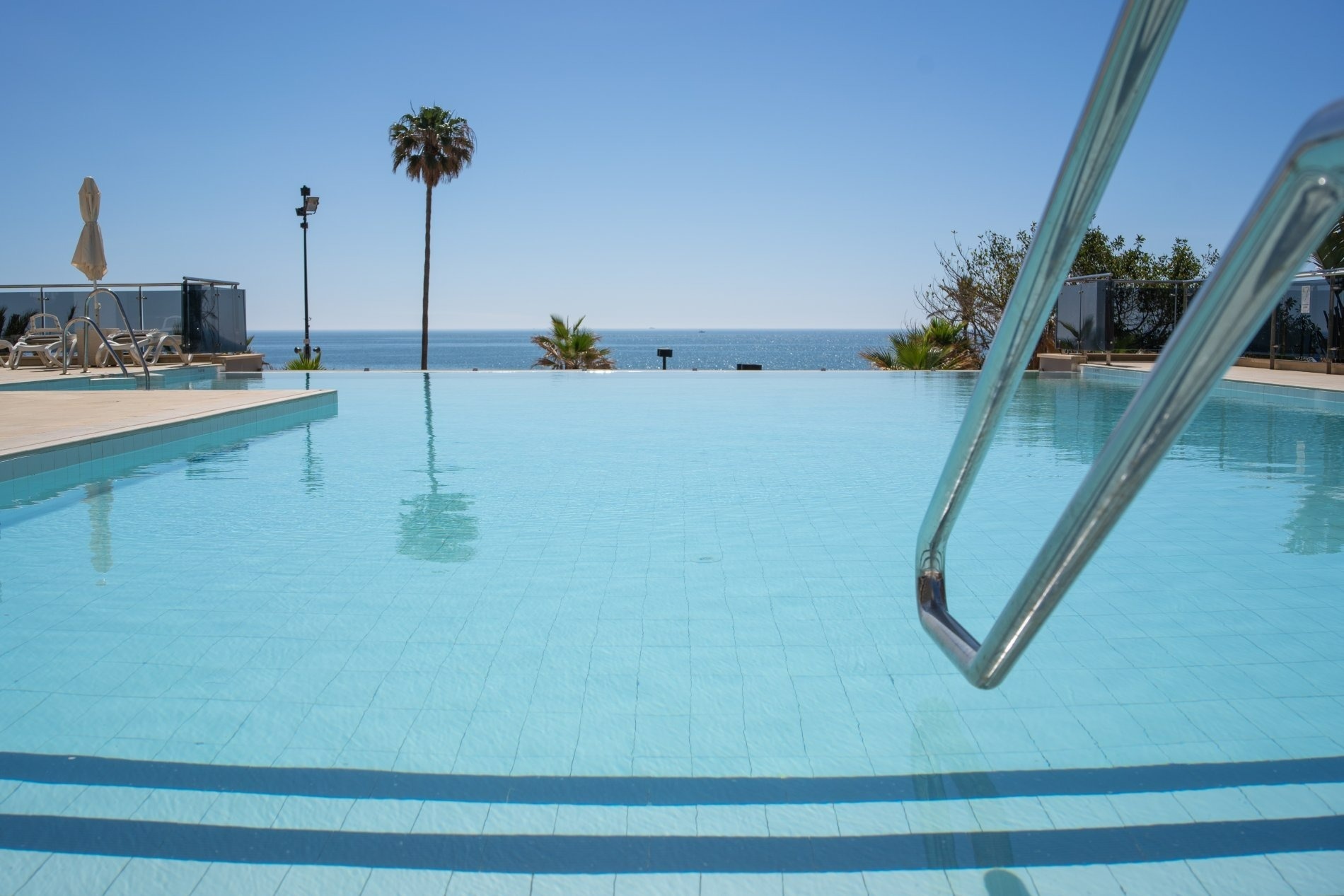 a swimming pool with the ocean in the background