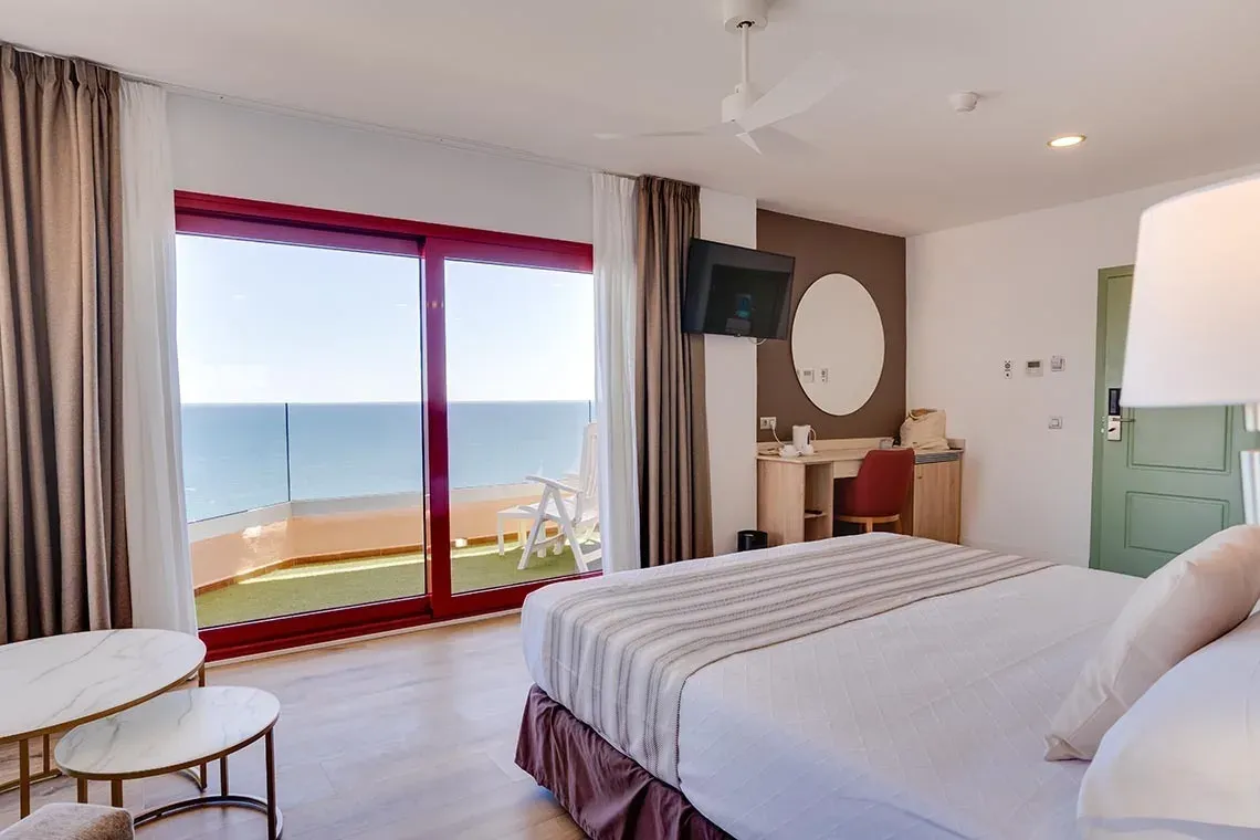 Habitación de lujo con vistas al mar, balcón y mobiliario moderno. ¡La Ángela te espera!
