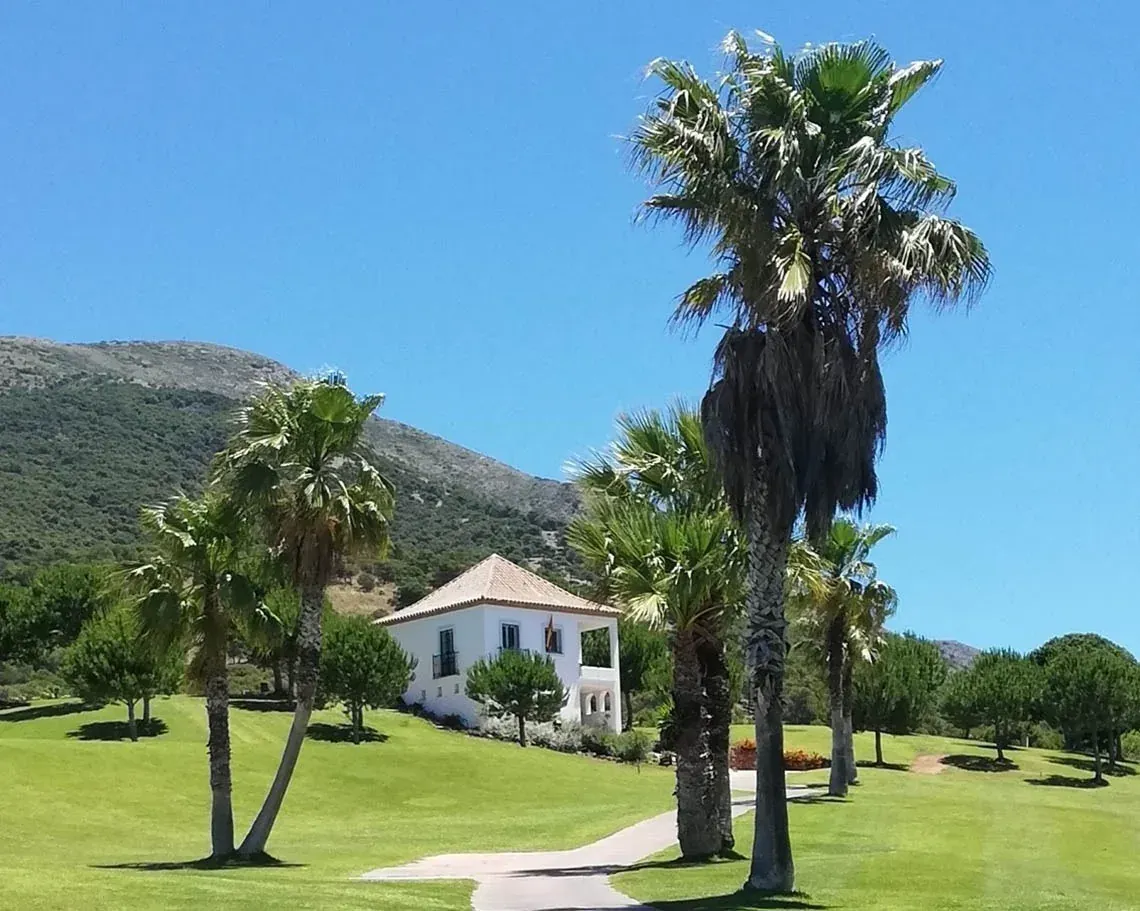 Villa Angela: hermosa casa blanca con palmeras en un campo de golf verde.