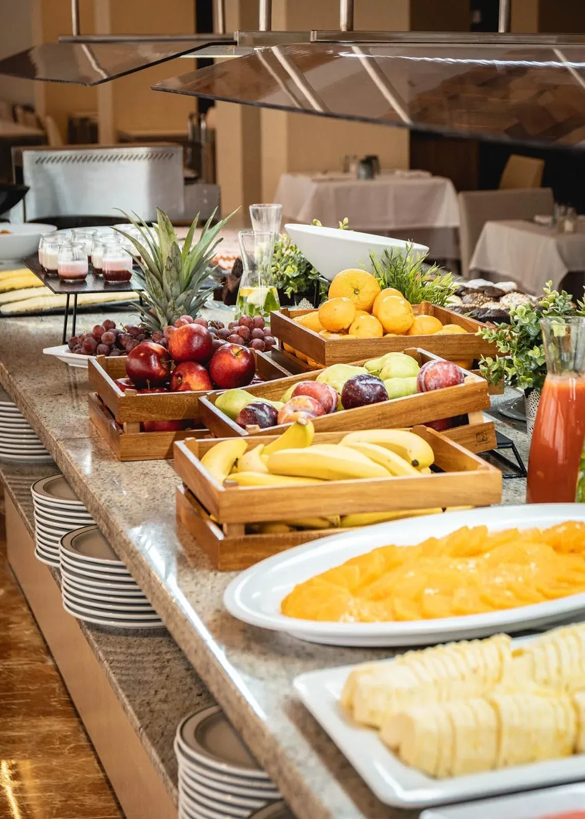 Buffet de petit-déjeuner Angela avec fruits frais, yaourts et jus.