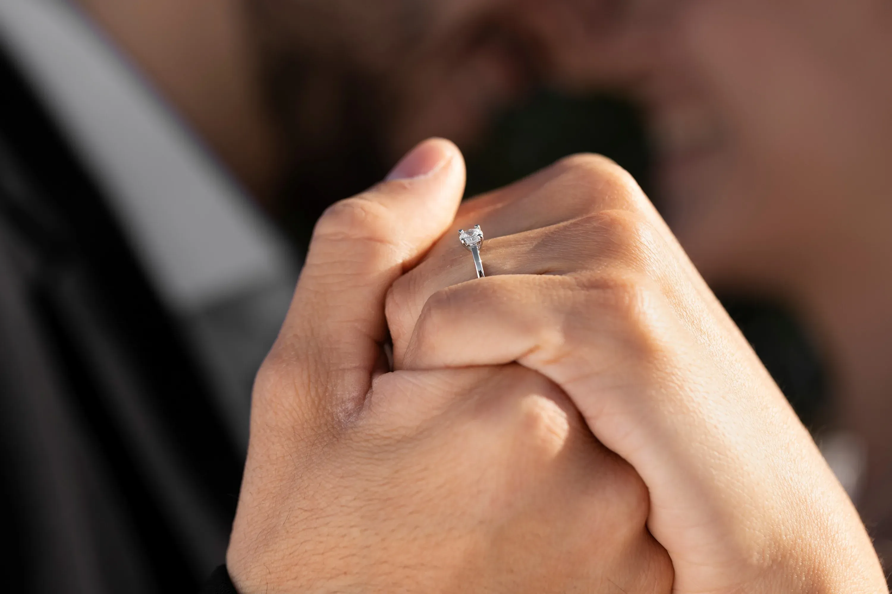 Angela's engagement ring, hands intertwined, symbolizing love and union.
