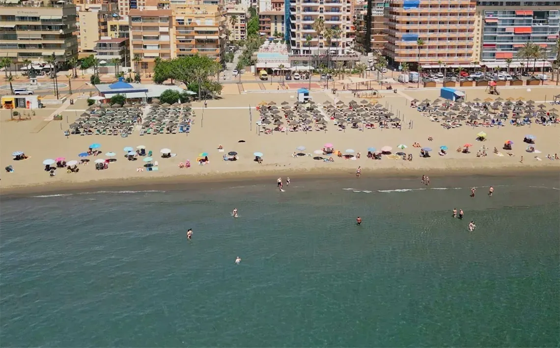 Vue aérienne de la plage de l'Hôtel Angela avec parasols et baigneurs.
