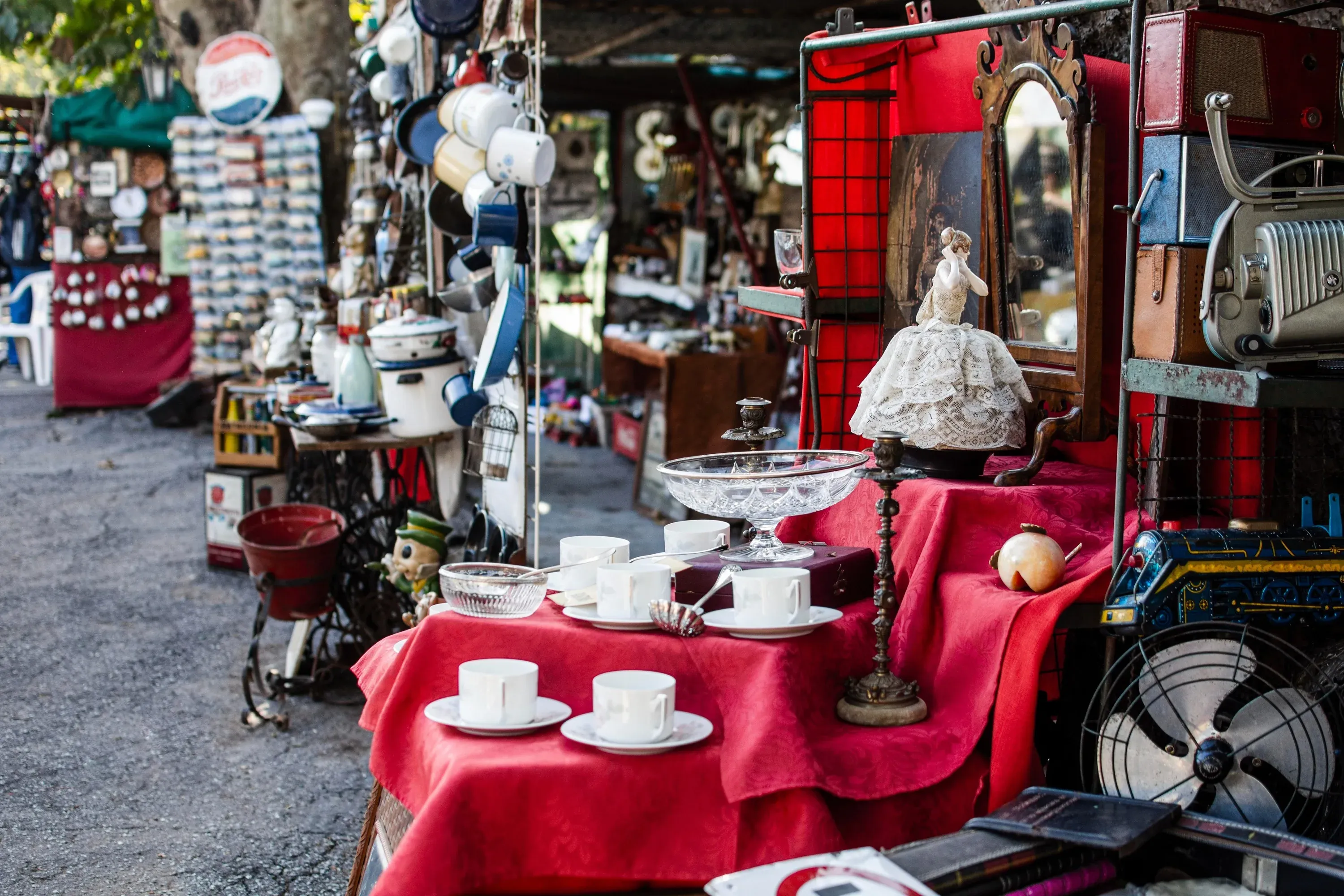 Articles d'occasion au marché aux puces, avec une figurine d'Angela et des bibelots.