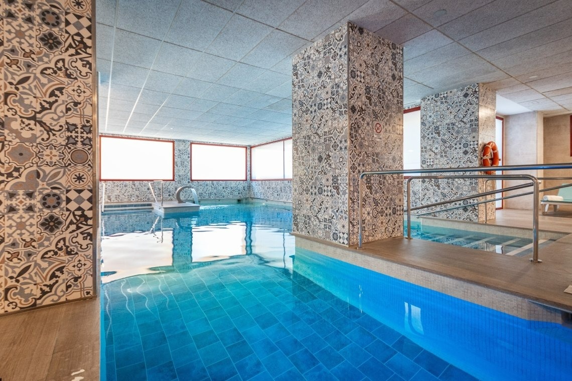 a large indoor swimming pool with blue tiles