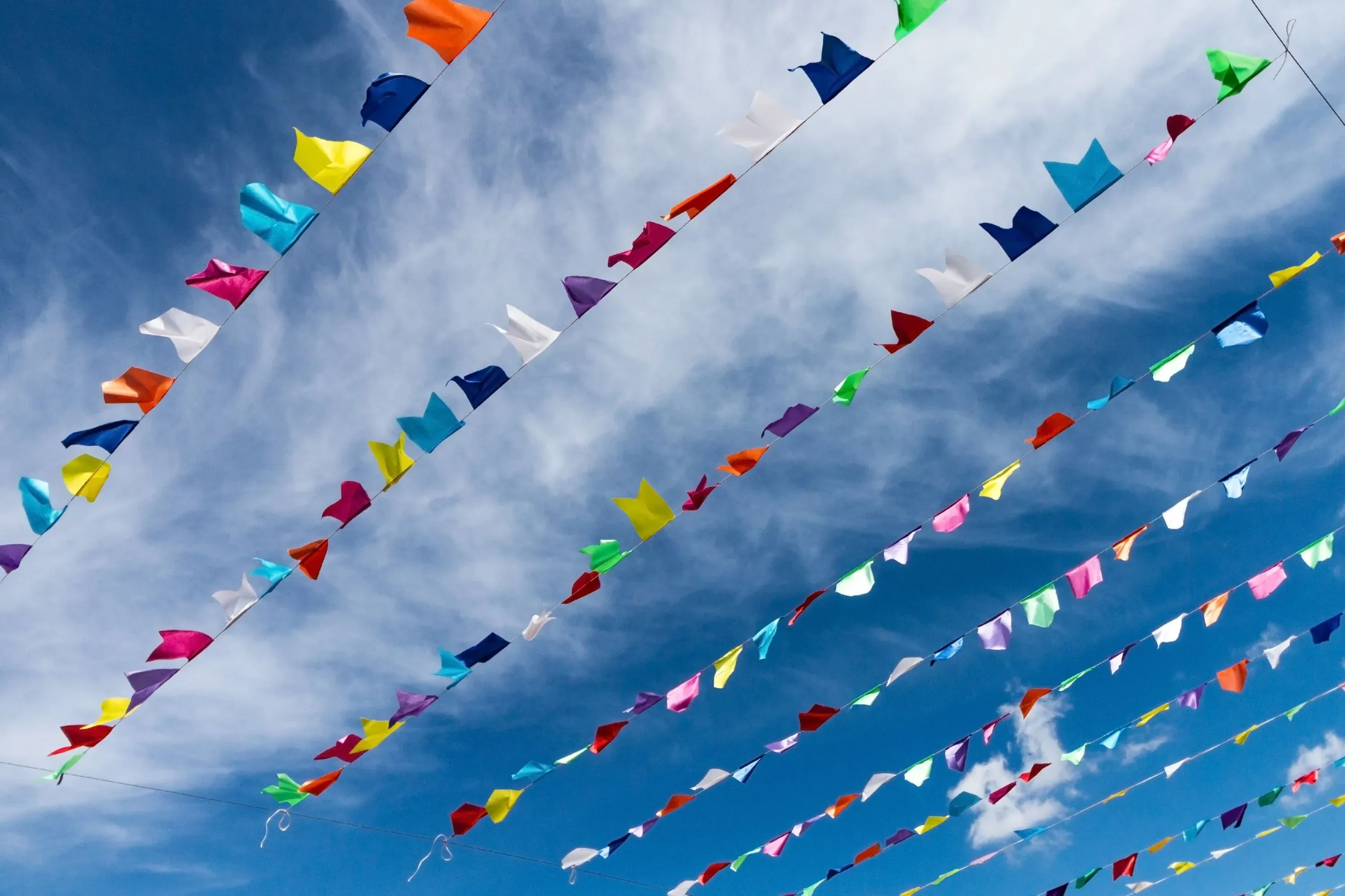 Angela's colorful flags flutter against a bright blue sky.
