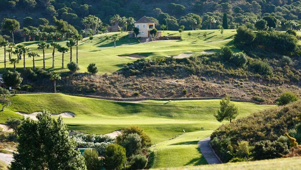 Campo de golf Angela con colinas verdes y casa. Perfecto para disfrutar al aire libre.