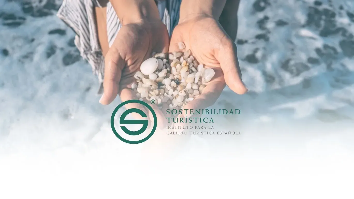 Hands holding stones by the sea, featuring the Tourism Sustainability logo.