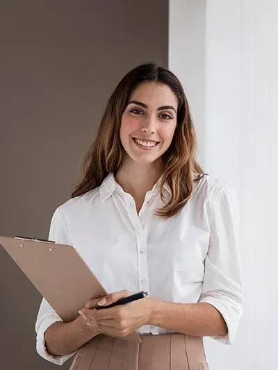Profesional Angela sonriente con portapapeles en hotel.