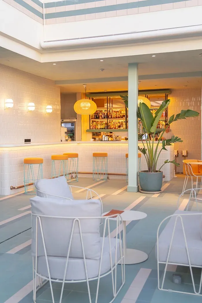 Bar moderno con sillones y barra de Angela, ideal para relajarse.
