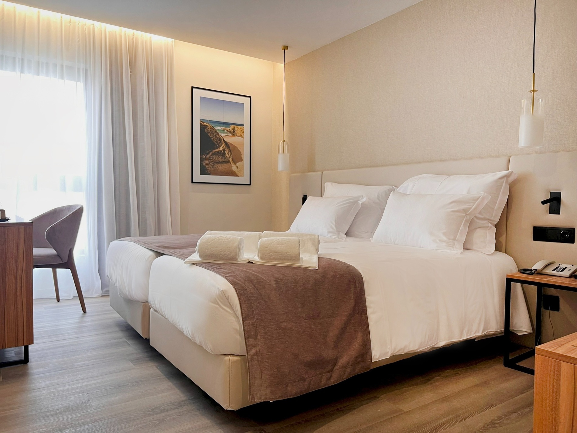 una habitación de hotel con dos camas y una pintura en la pared