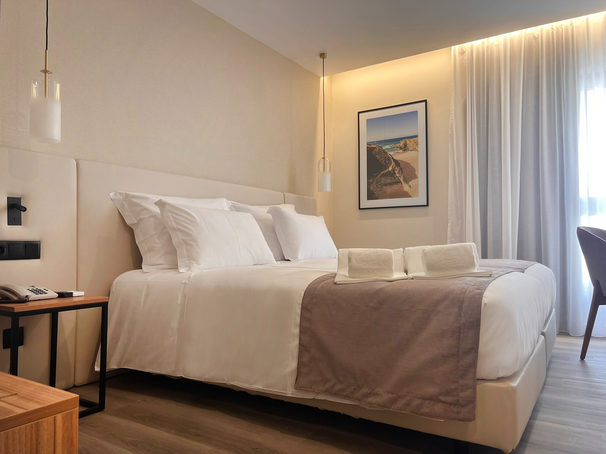 um quarto de hotel com cama e mesa de cabeceira