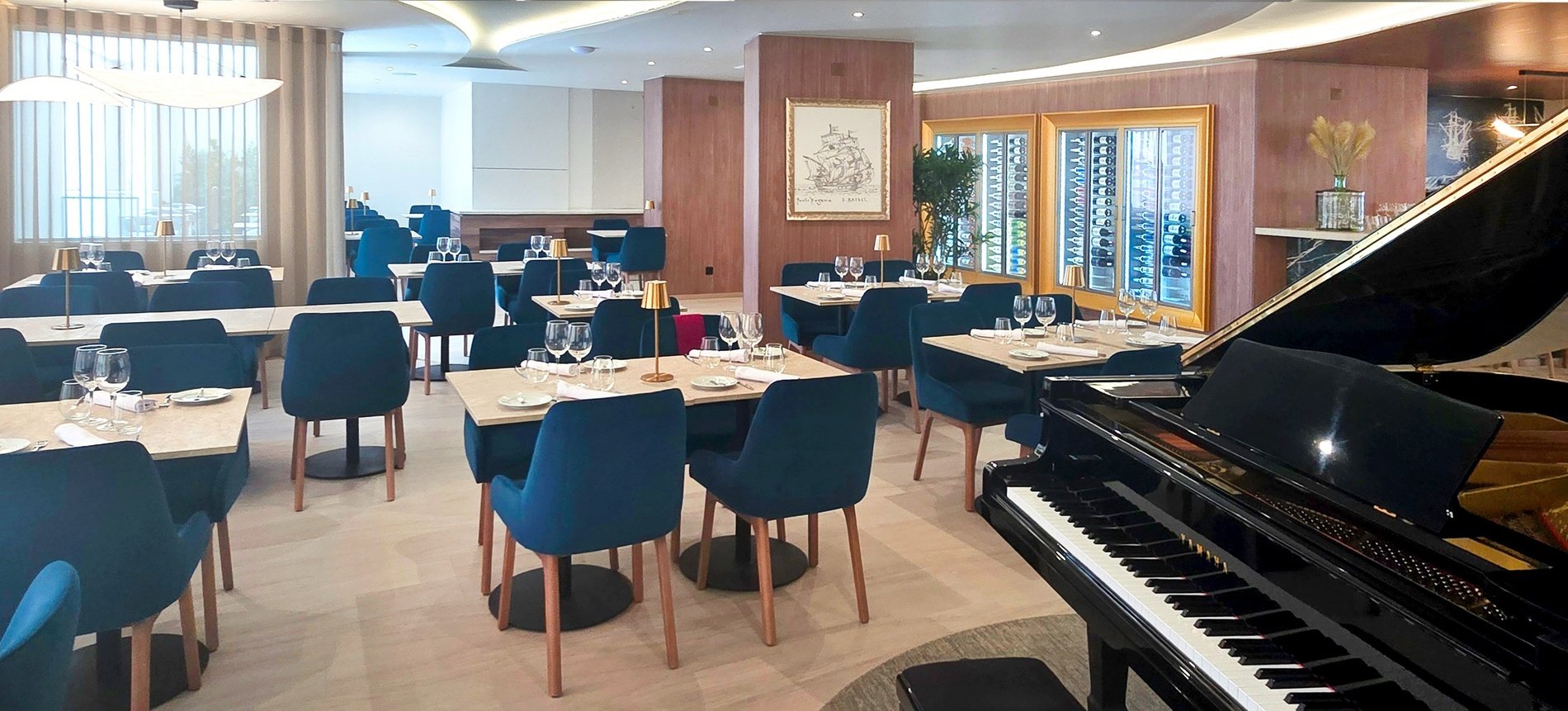 un restaurante con mesas y sillas azules y un piano