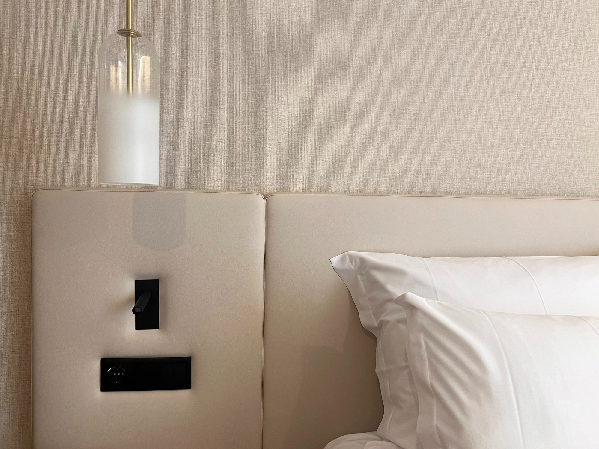 una habitación con una cama blanca y una lámpara colgante