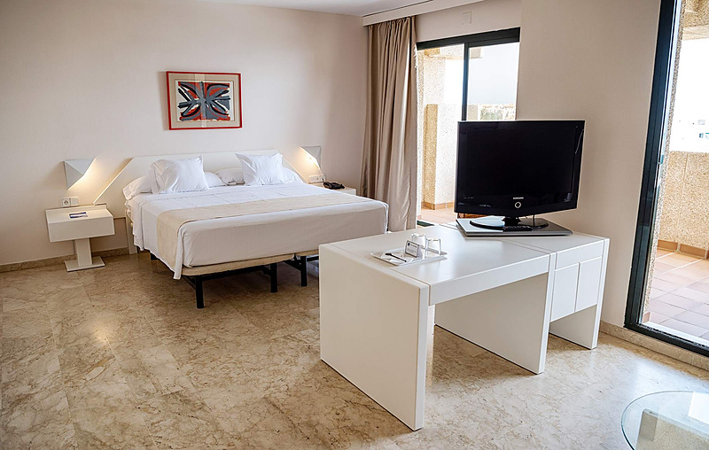 Habitación de hotel con cama, balcón y vistas al mar en AR: Almerimar.