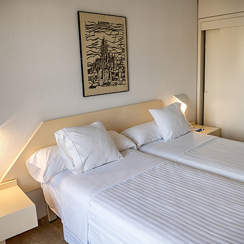 Habitación doble con camas twin, ropa de cama blanca yAR: Almerimar moderna.