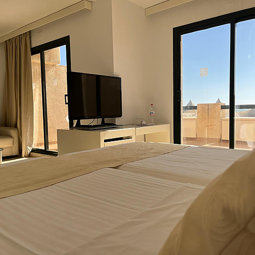 Habitación con dos camas, TV, balcón y vista al mar. AR: Almerimar