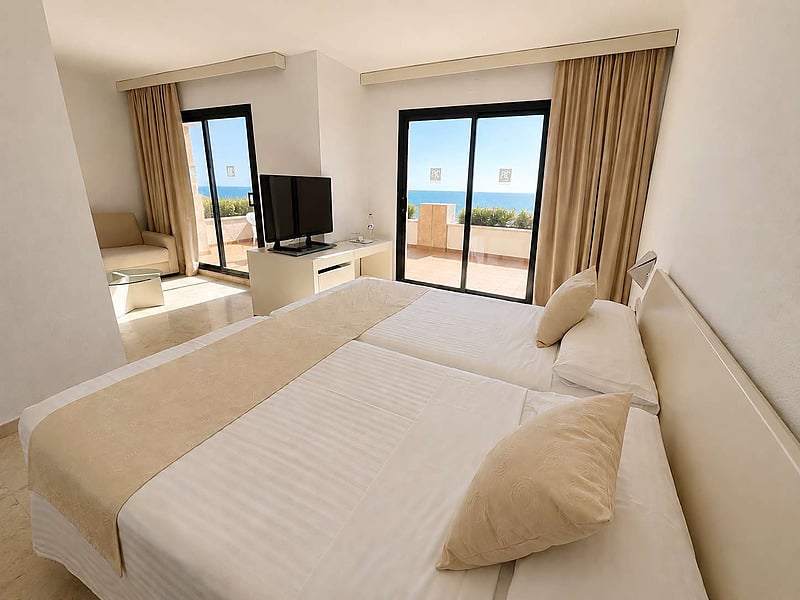Habitación de hotel con cama, balcón y vistas al mar en AR: Almerimar.