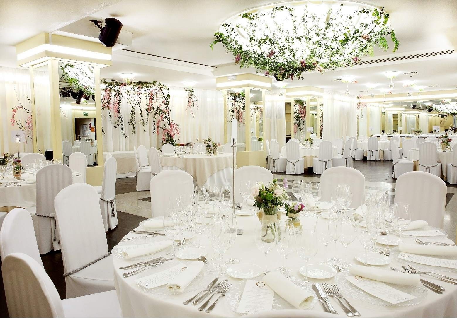 una habitación decorada para una boda con mesas y sillas blancas