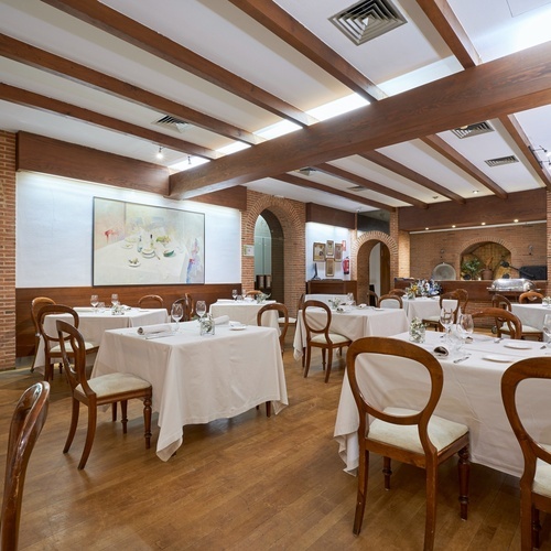 a restaurant with tables and chairs and a painting on the wall