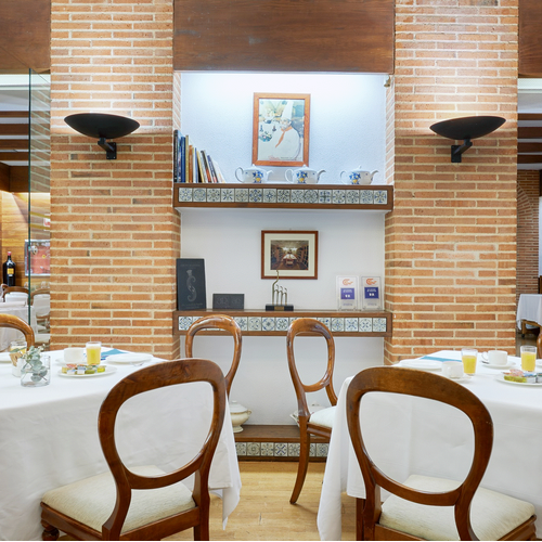 a restaurant with tables and chairs and a brick wall