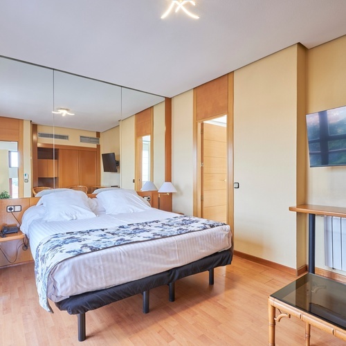 a hotel room with a bed and a flat screen tv