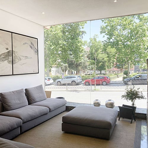Elegant hotel lounge with leather sofas, city view, and contemporary art. Features AR: Arcos design.
