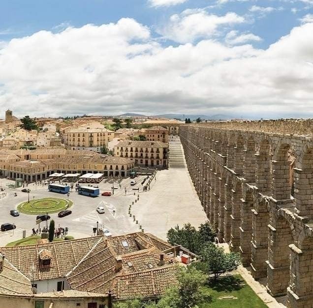 an aerial view of a city with an aqueduct in the foreground