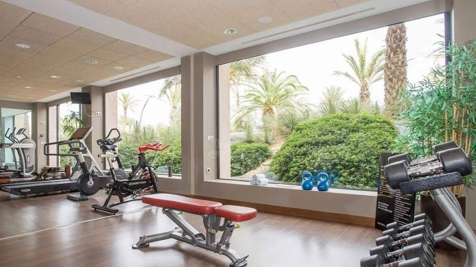 un gimnasio con muchos equipos y una gran ventana