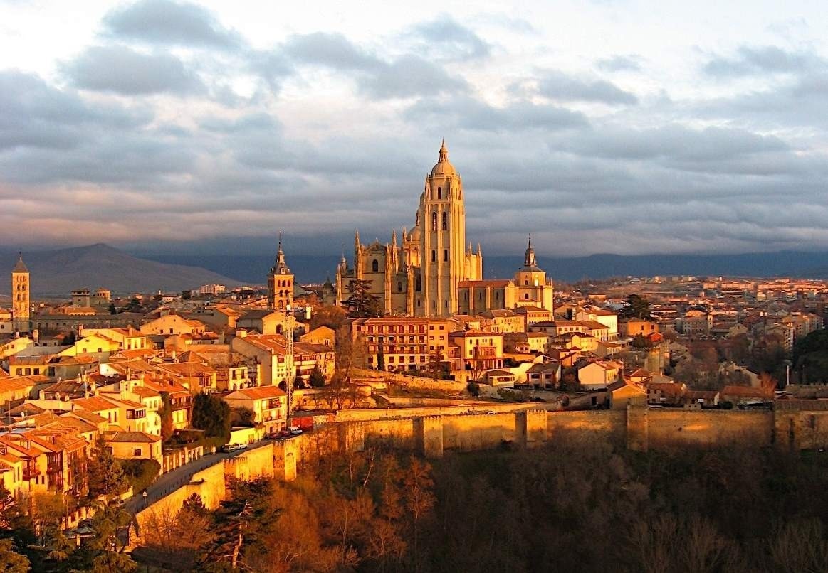 an aerial view of a city with a large cathedral in the background