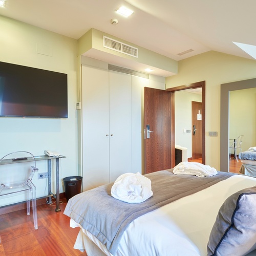 a bedroom with a large flat screen tv above the bed