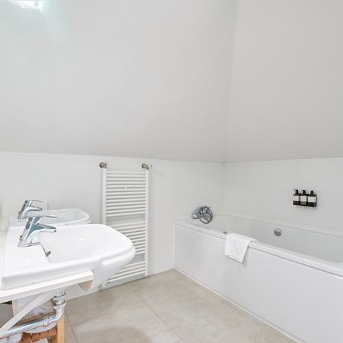 a bathroom with two sinks and a bathtub