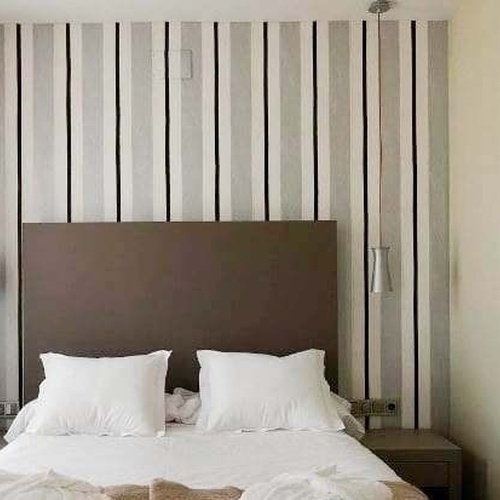 una habitación con una cama y una pintura de una mujer en la pared .