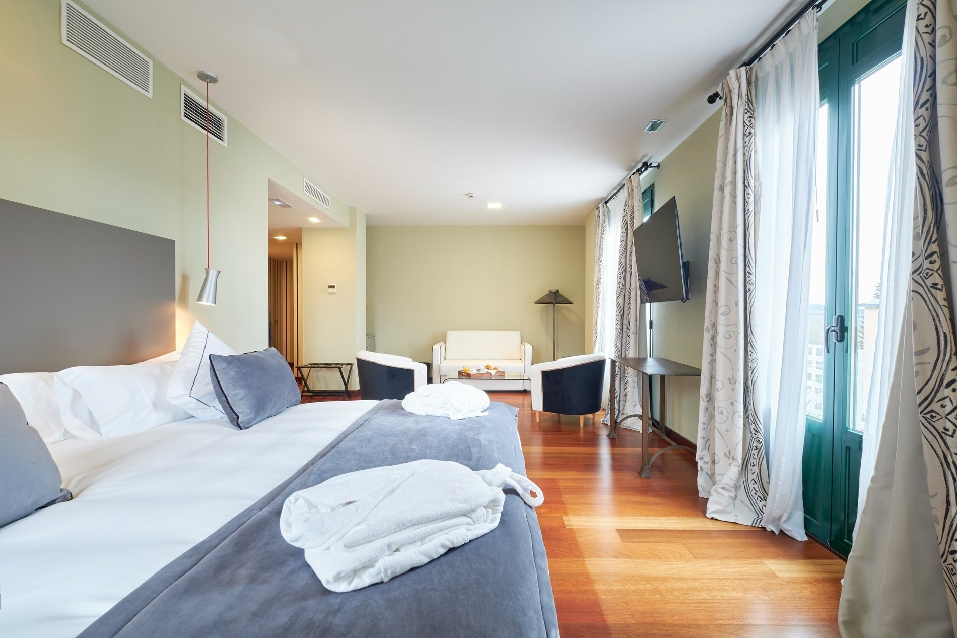 a hotel room with a large bed and two chairs