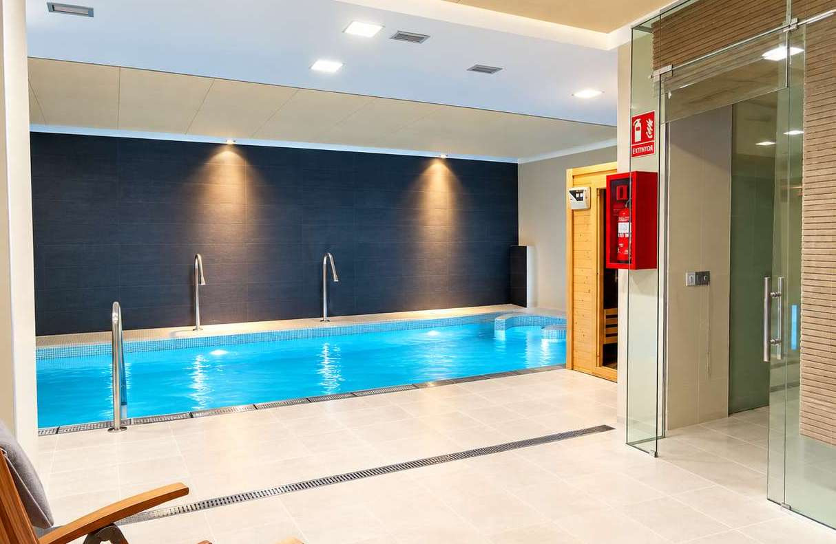 Mujer relajándose en jacuzzi con iluminación azul, experiencia AR: Isabel de Farnesio.
