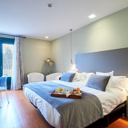 a hotel room with a tray of food on the bed