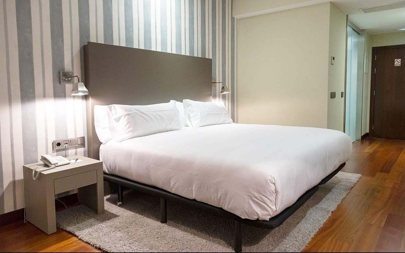 una habitación de hotel con una cama y una mesita de noche