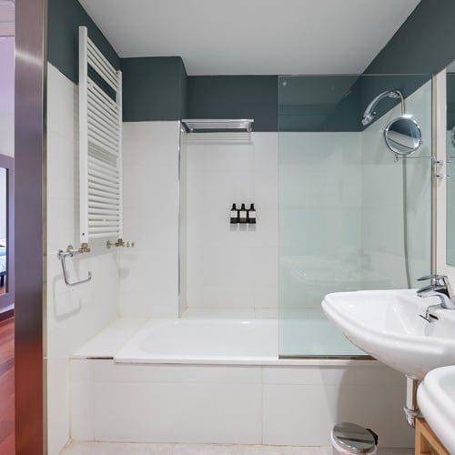 a bathroom with a bathtub sink and mirror