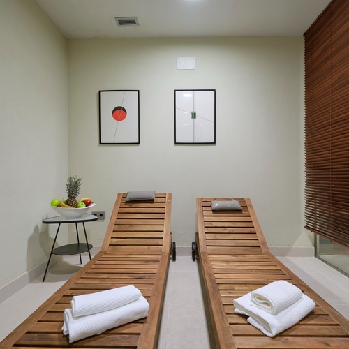 two wooden lounge chairs with towels on them in a room