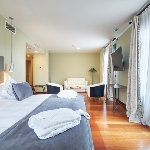 a hotel room with a large bed and two chairs