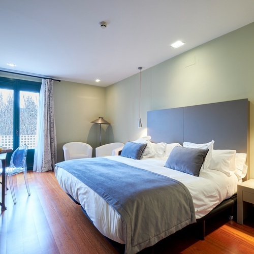 a hotel room with a large bed and chairs