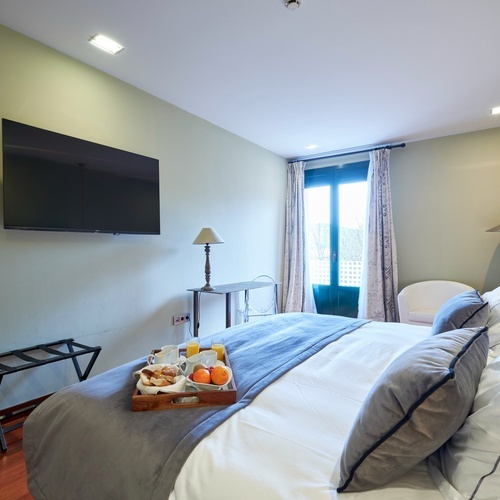 a hotel room with a tray of breakfast on the bed