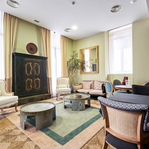 a living room with a fireplace and a painting of a woman on the wall