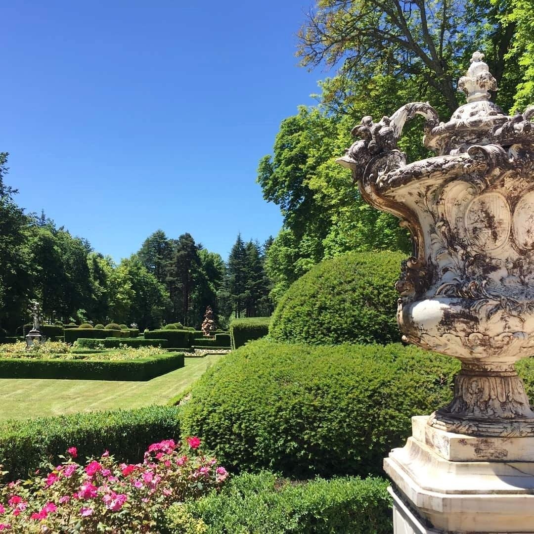 un gran palacio rodeado de flores y hierba .