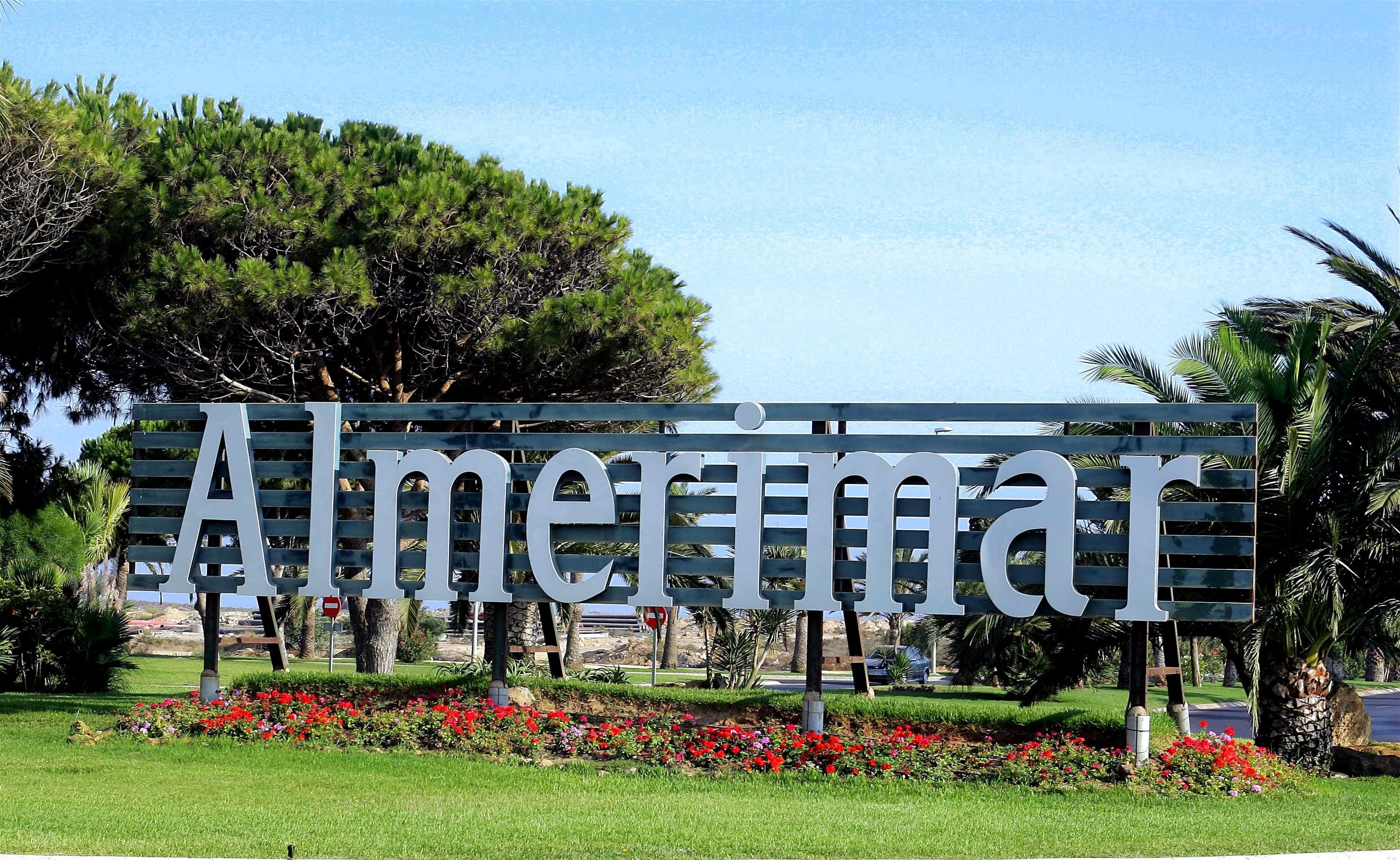 un cartel que dice almeria está rodeado de árboles y flores