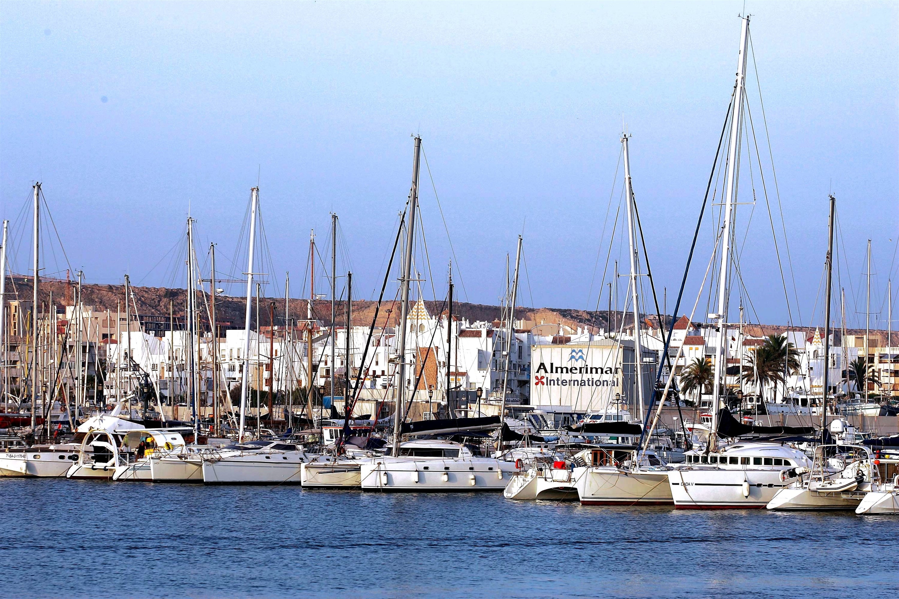 un grupo de barcos están amarrados en un puerto y uno de ellos tiene la letra a en el casco