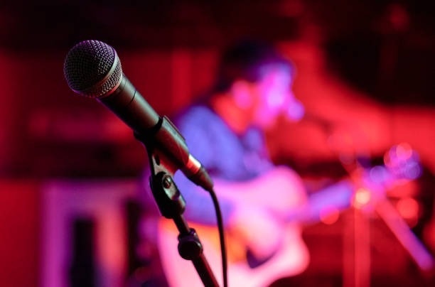 a close up of a microphone on a stage with lights in the background .