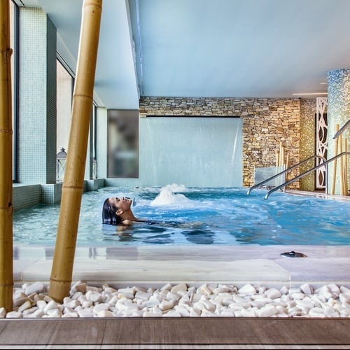 una mujer se relaja en una piscina dentro de un spa