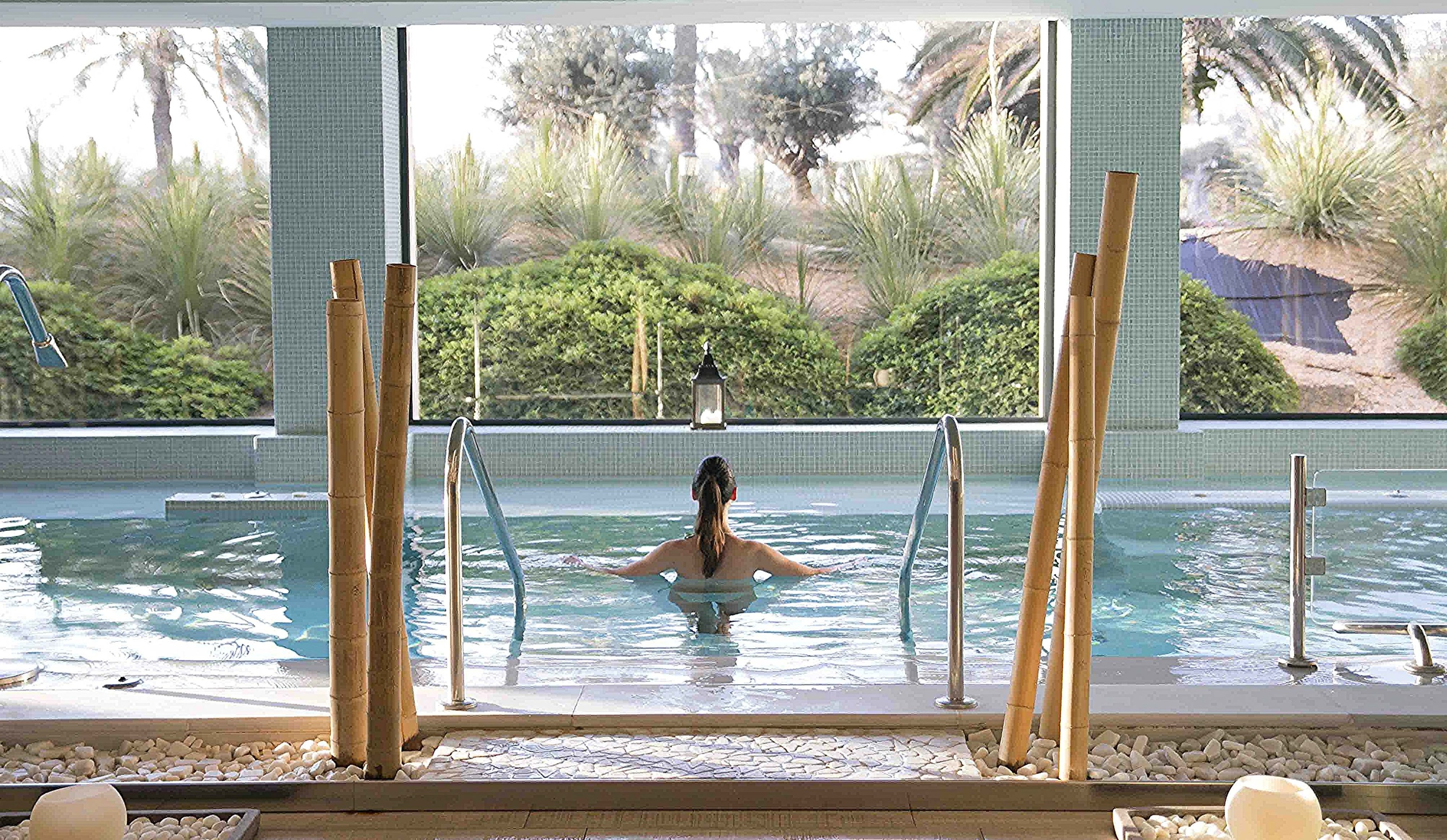 una mujer está sentada en una piscina mirando por la ventana