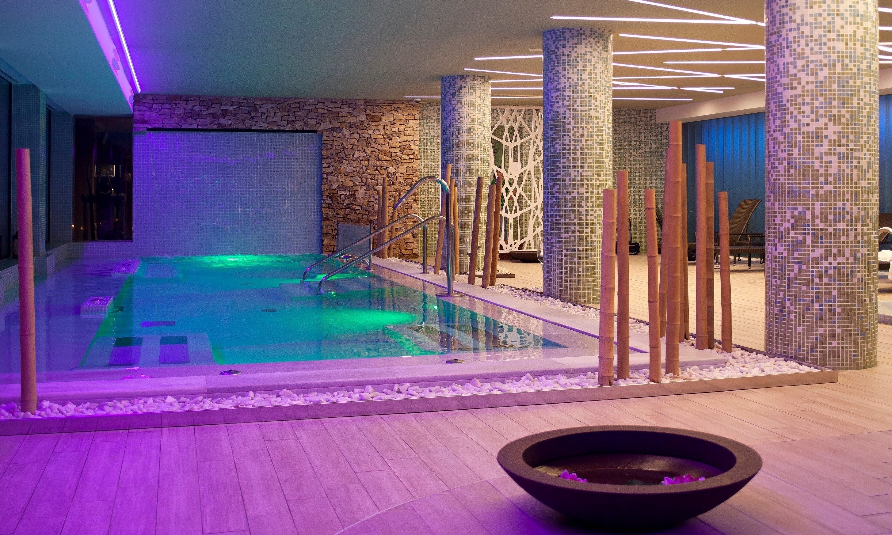 a swimming pool in a spa with purple lights